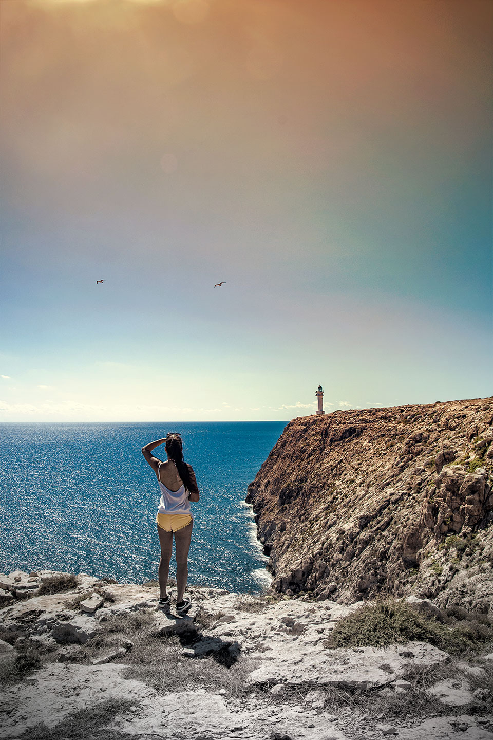Girl looking at the lighthouse Far del Cap de Barbaria, Formentera, Spain, (Nos Dren)