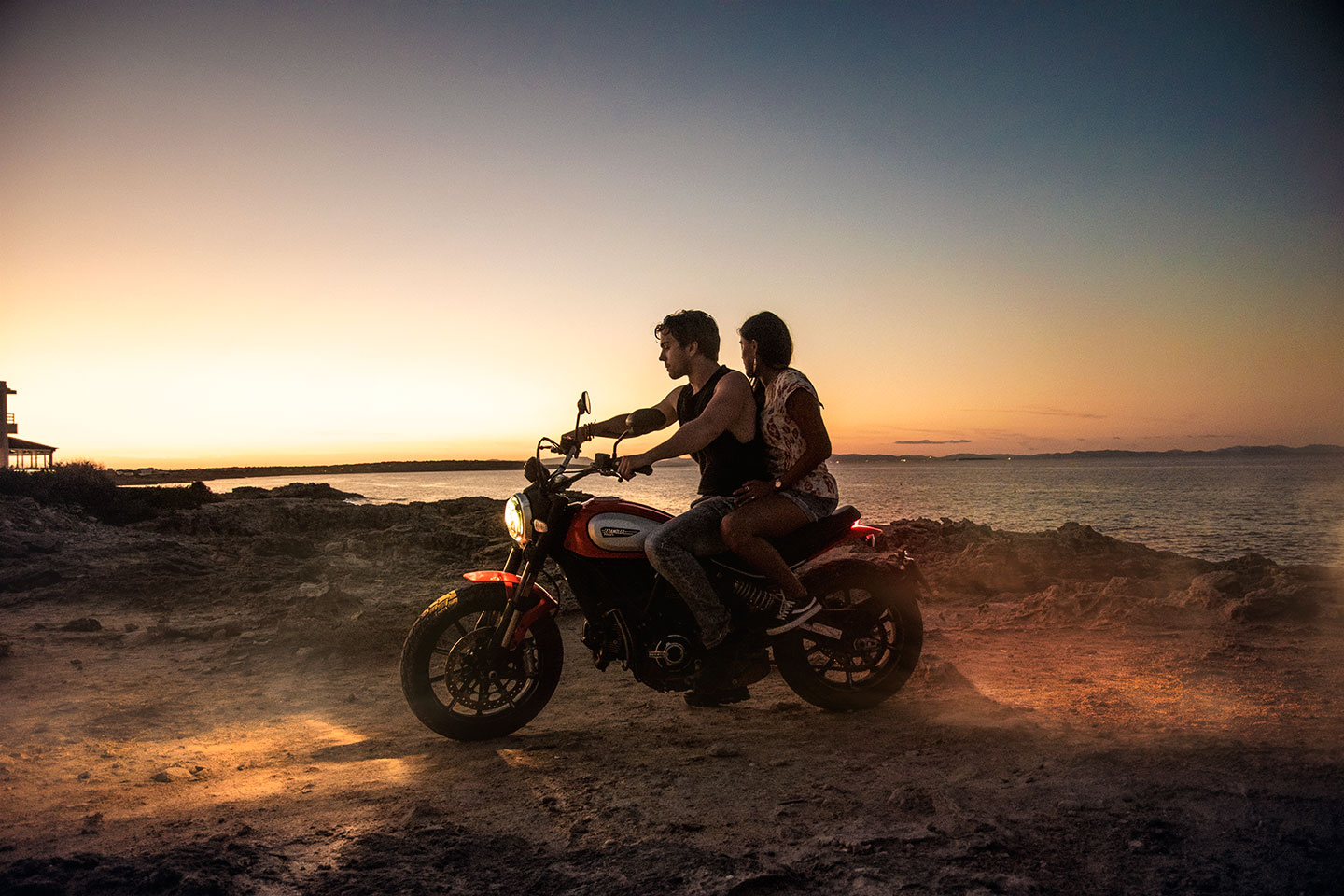 Shadowed couple riding a motorcycle by sunset back light at Es Calo, punta des Pou des Verro, Formentera, Spain, (Nos Dren)