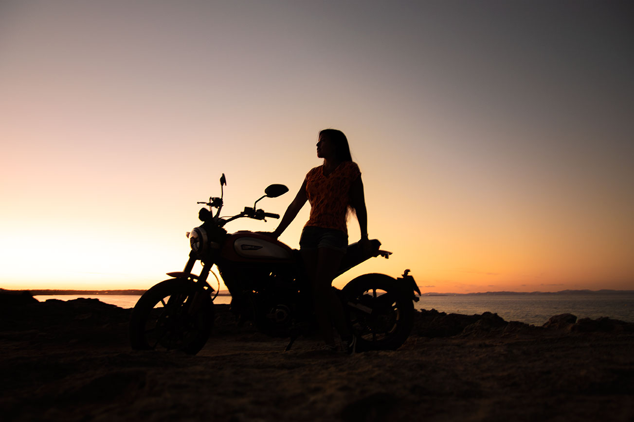 Shadowed motorcycle and girl by sunset at Es Calo, Formentera, (Nos Dren).