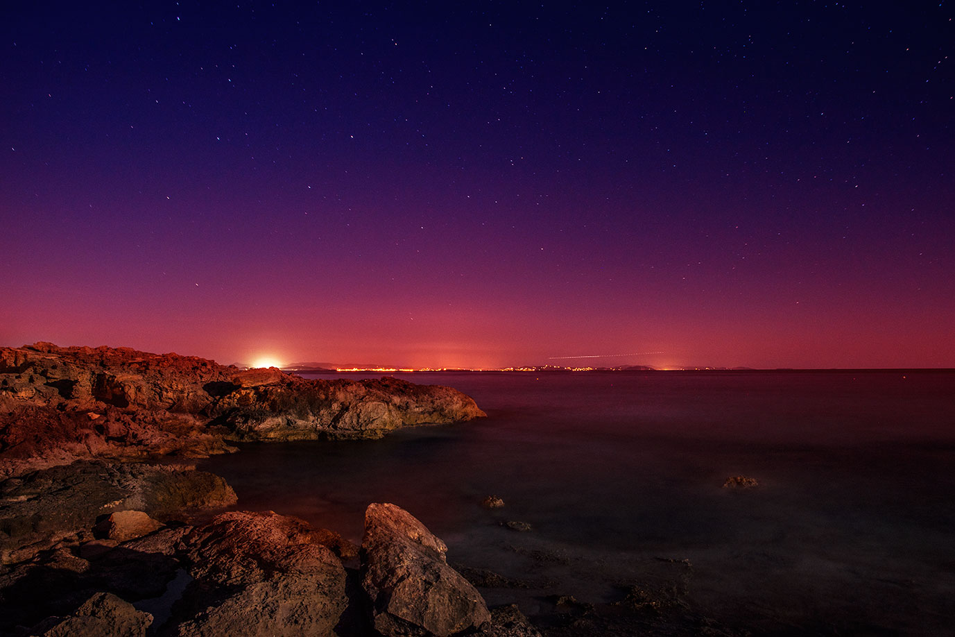 Slow speed shutter night photography with stars above Ibiza from Es Calo, Formentera, Spain, (Nos Dren).