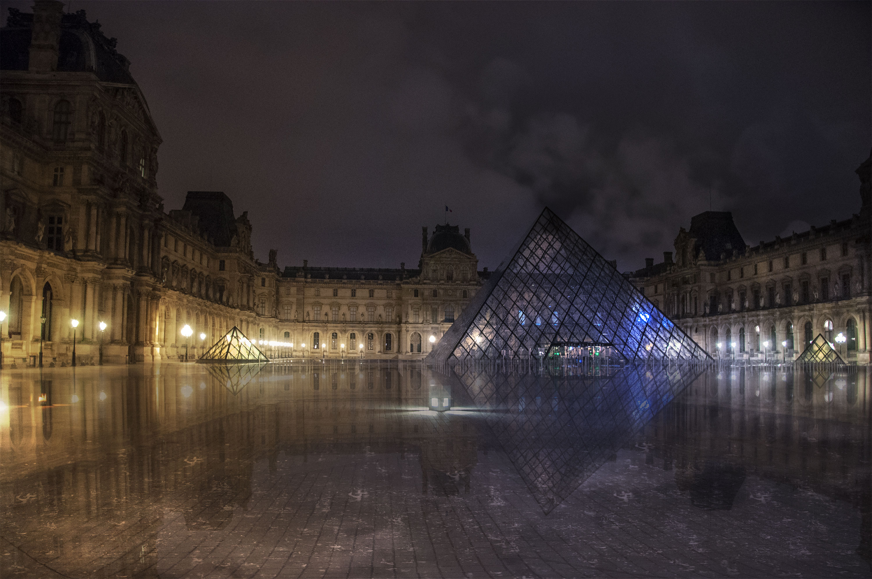 Louvre museum pyramids under cloudy night with nobody around, (Nos Dren).
