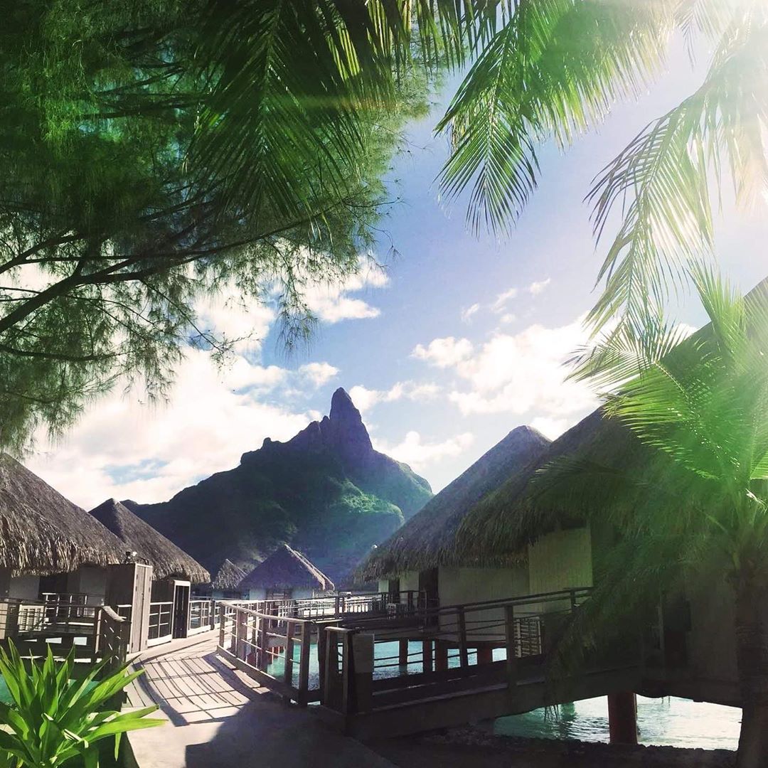 French Polynesia, Bora Bora island, Mount Otemanu view from the stilt houses and palm trees from Le Meridien Bora Hotel. (Nos Dren)
