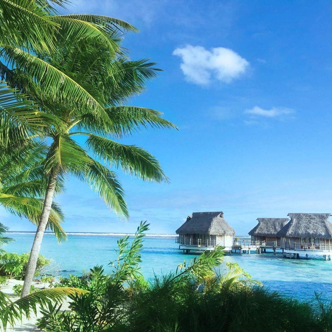 French Polynesia, Bora Bora island, paradise beach with coco trees and palm trees, blue lagoon and stilt houses. (Nos Dren)