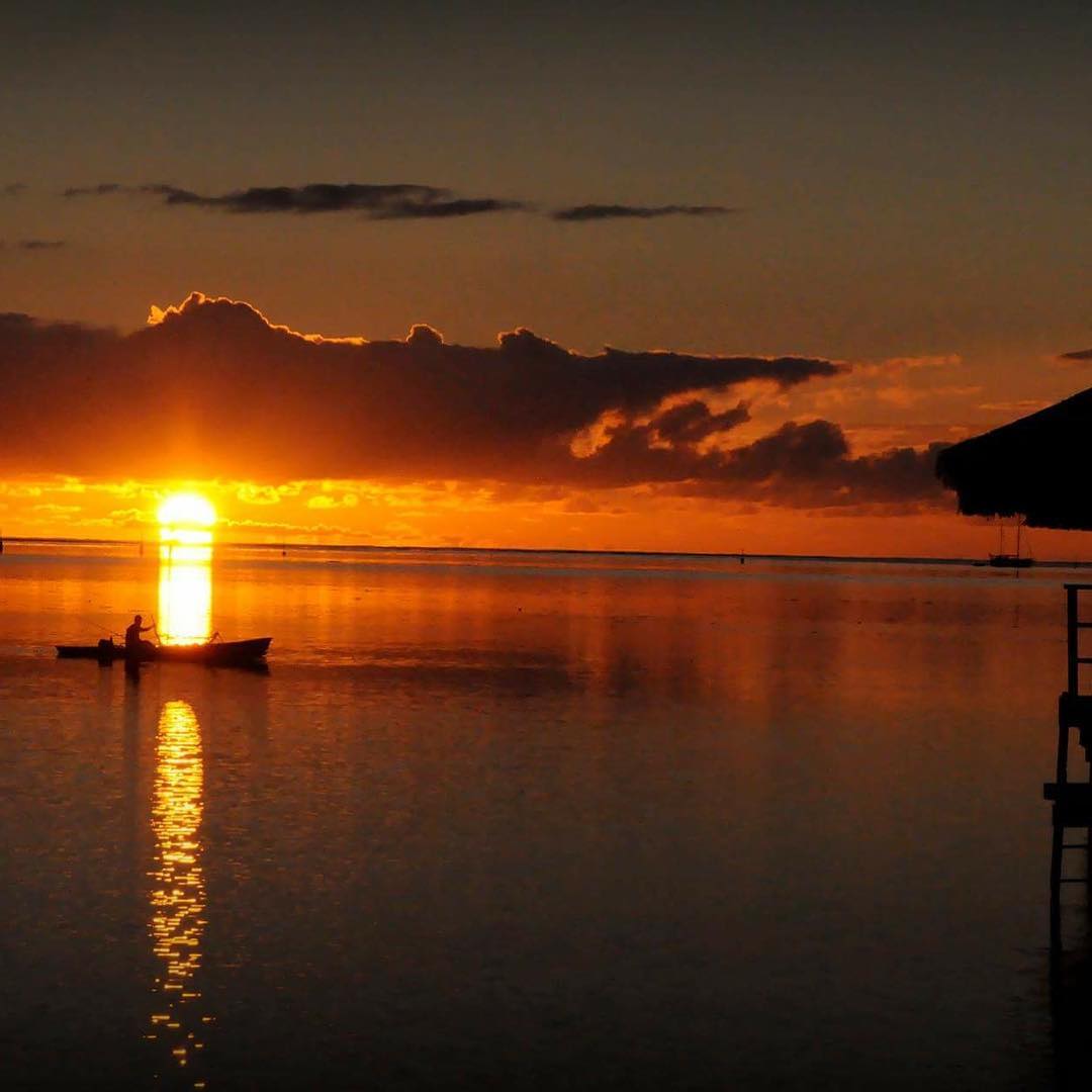 French Polynesia, Moorea or Mo'orea island, fisherman returning to harbor by sunrise with a nice contrast. (Nos Dren)