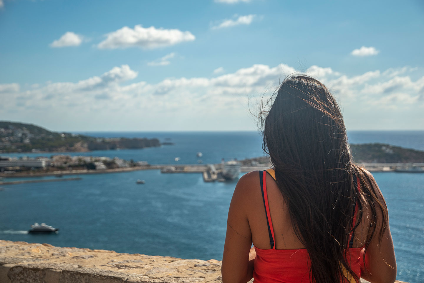 Girl watching Eivissa harbour and city of Ibiza from Castell d'Eivissa, Catalonia, Spain. (Nos Dren).